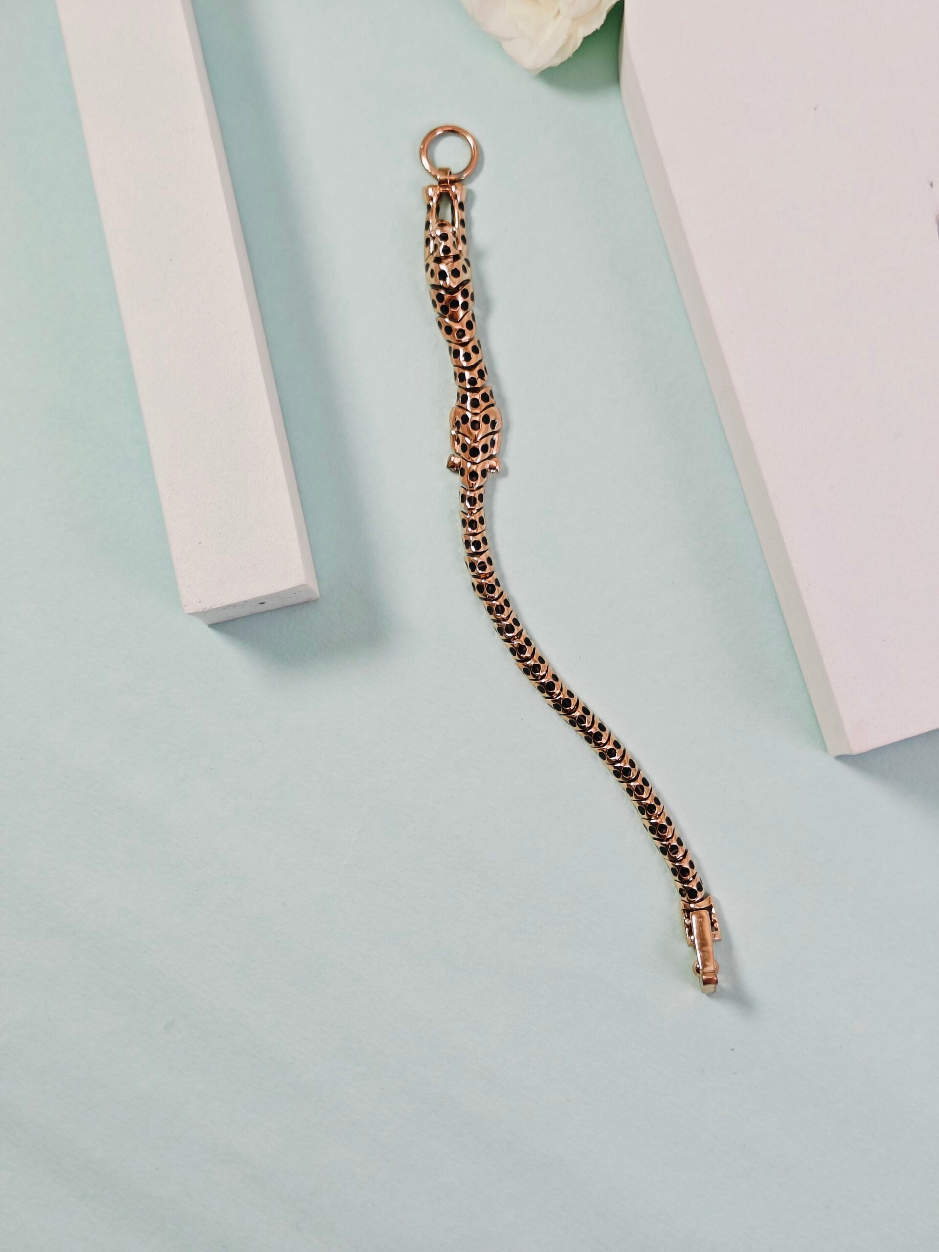 Gold chain bracelet on a light blue background